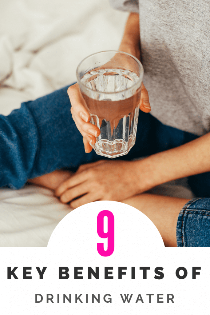 Woman sitting down to drink a glass of water with text below 9 Key benefits of drinking water