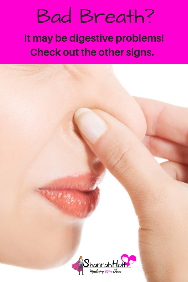 Woman holding her nose. Do you have bad breath? Check out these signs of digestive problems. 