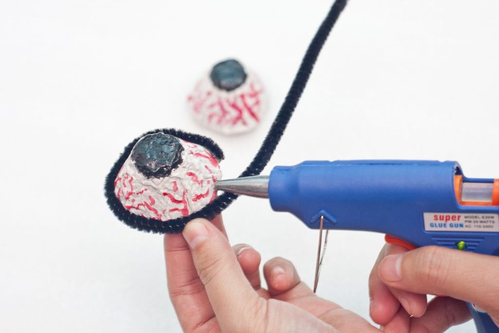 Halloween DIY Creepy Eyeball Glasses Step 5: Wrap the black pipe cleaner on the edge of the widest part of the eyeball. 