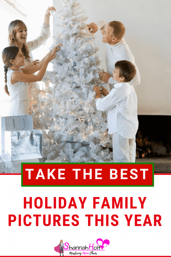 Mom dad daughter and son all decorating the Christmas tree dressed in white and the tree is all white. Perfect holiday family picture. 
